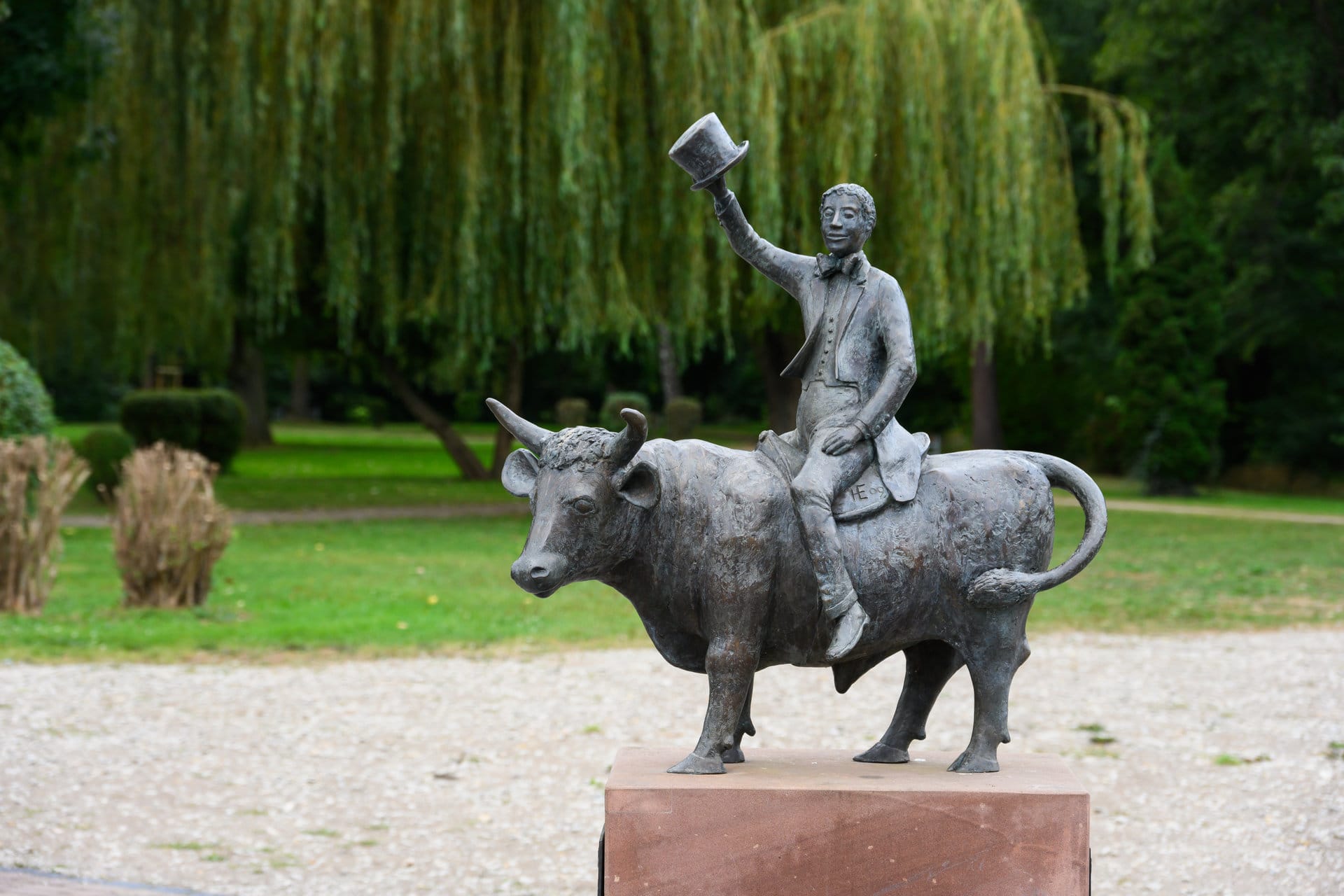 Bronzeskulptur eines Mannes auf einem Stier in einer Parkanlage in Uder, Eichsfeld