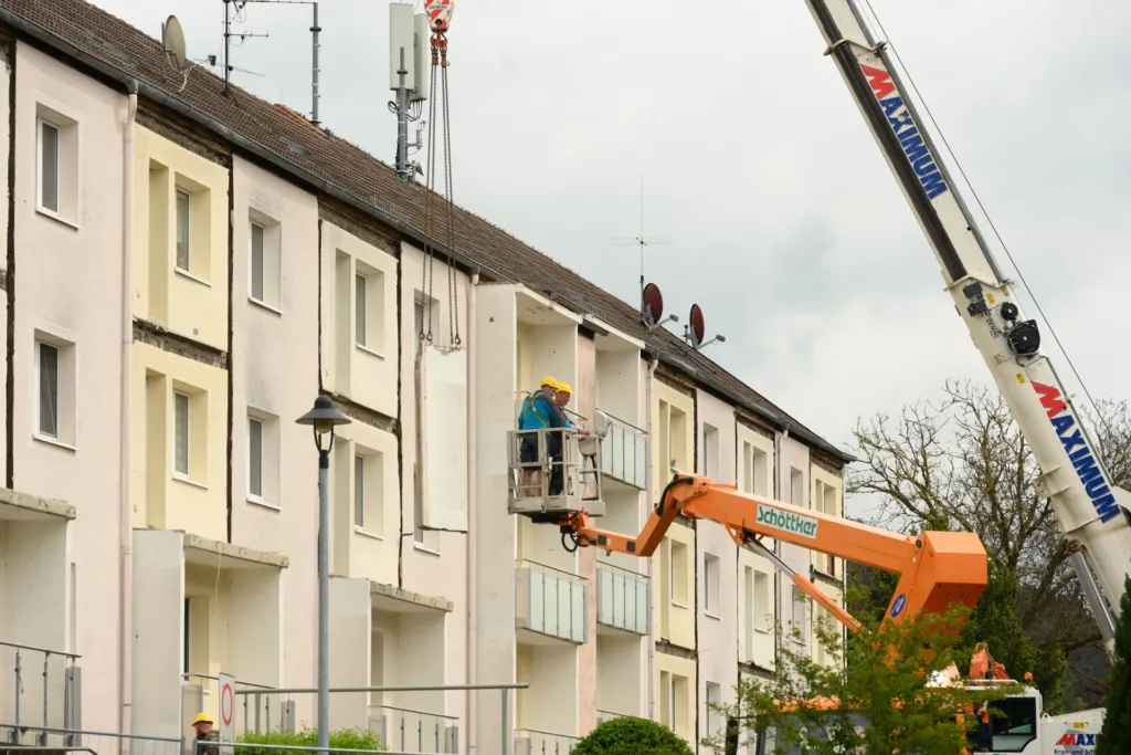 Arbeiter im Hubsteiger bei Fassadenarbeiten an der Bergstraße in Geismar während der Sanierung eines Wohngebäudes