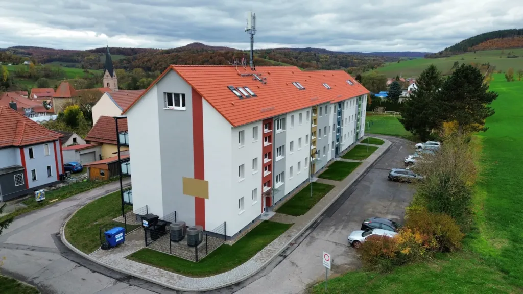 Saniertes Mehrfamilienhaus der KOWO in der Bergstraße in Geismar mit neuer Fassade und Dach, Luftaufnahme.