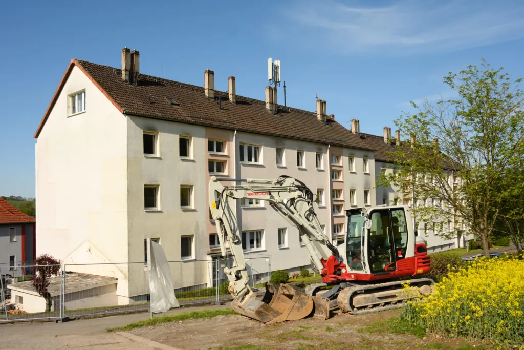 Mehrfamilienhaus in der Bergstraße Geismar mit Bagger vor der Fassade zu Beginn der Sanierungsarbeiten