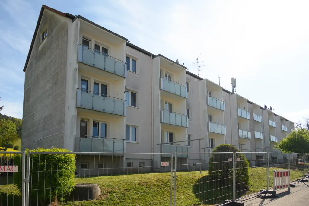 Mehrfamilienhaus mit Balkonen in der Bergstraße in Geismar, umgeben von Bauzaun während der Sanierungsarbeiten