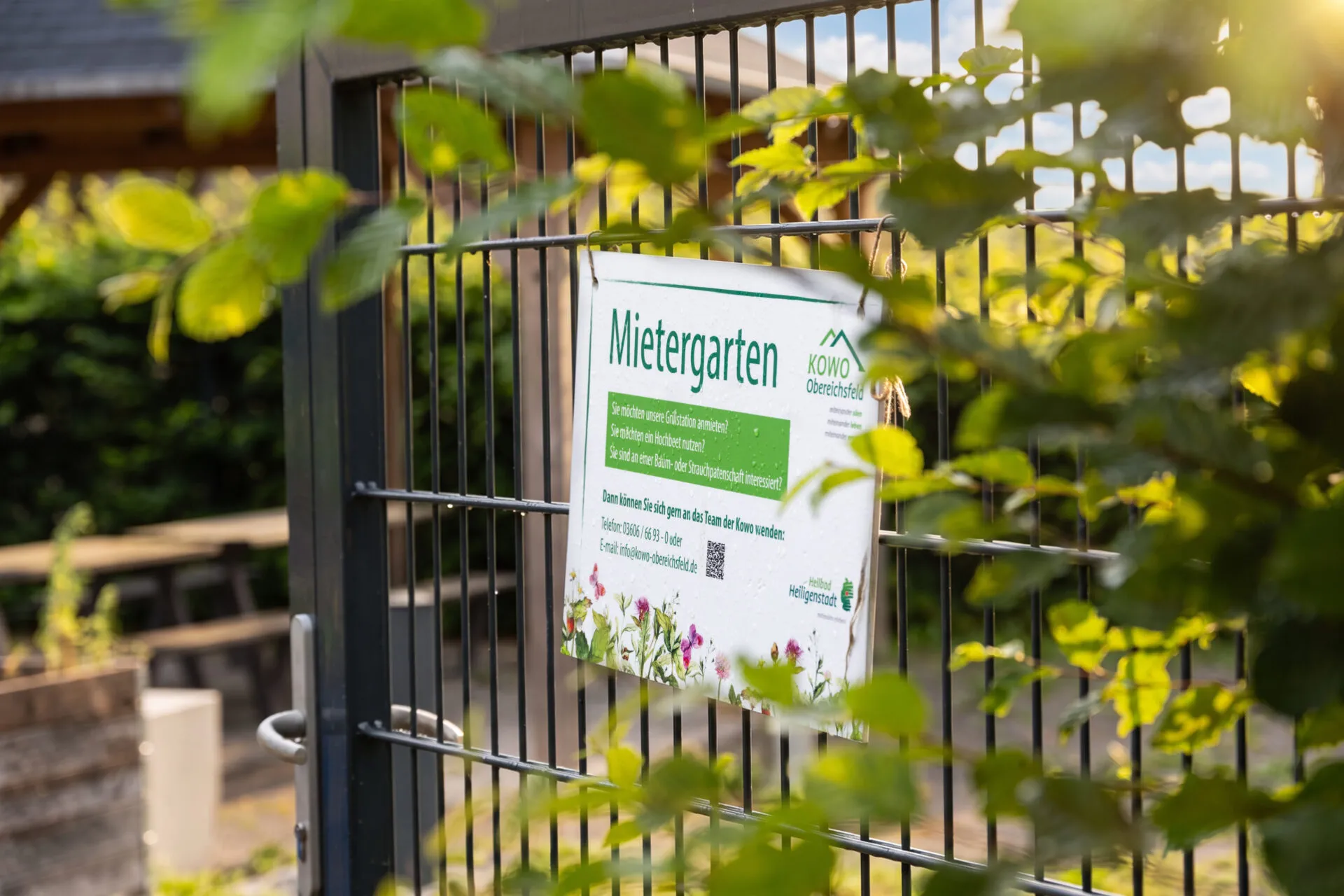 Schild "Mietergarten" am Gartenzaun der KOWO Obereichsfeld mit Infos zu Hochbeeten und Baumpatenschaften