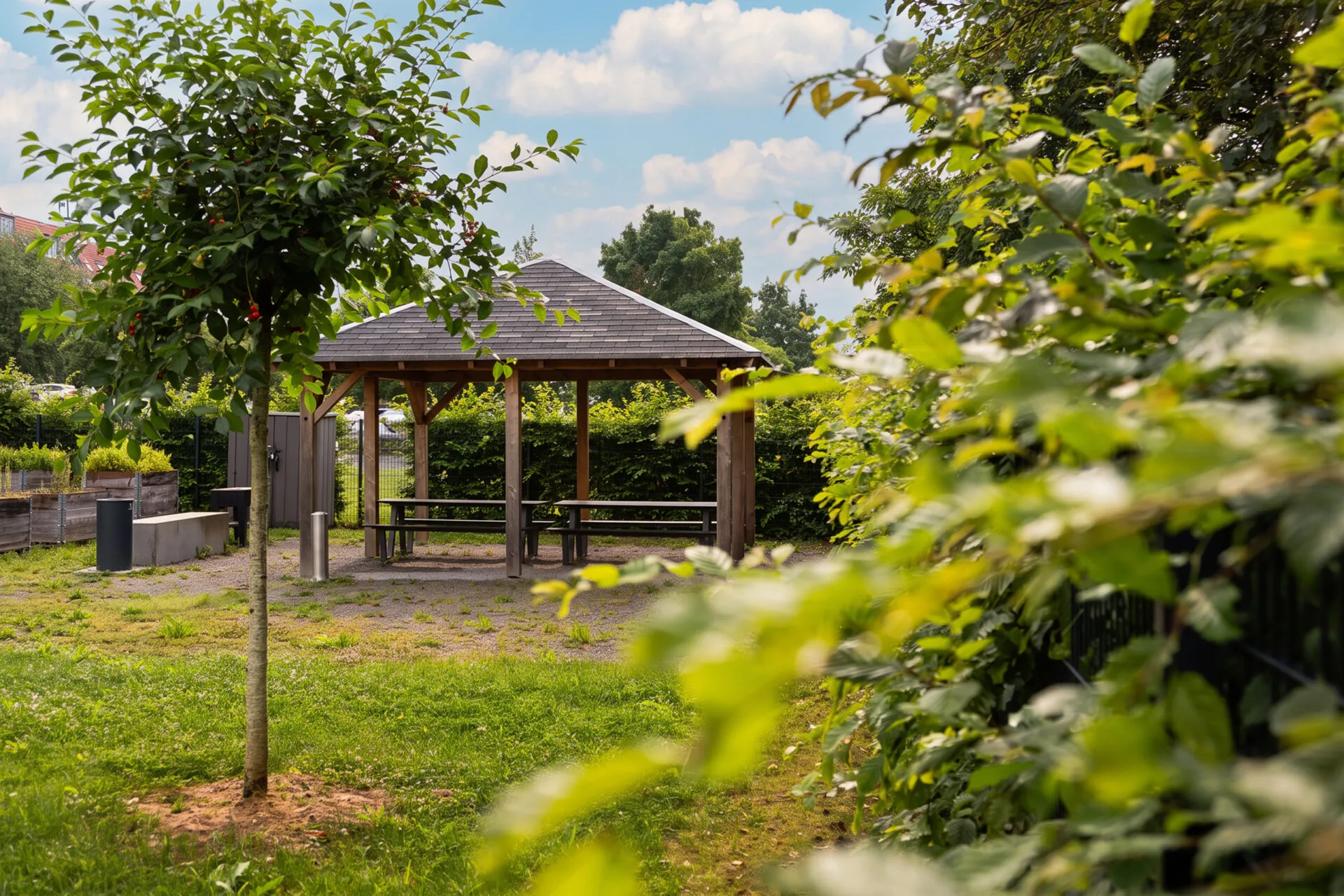Überdachter Sitzbereich mit Holzpavillon und Bänken in der Grünen Mitte der KOWO Obereichsfeld