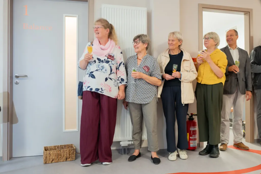 Frauen und ein Mann stoßen mit Sekt an bei der Eröffnung von ko-ra-le in der Wilhelmstraße 26