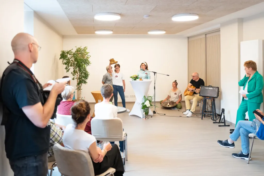 Eröffnungsfeier von ko-ra-le in der Wilhelmstraße 26 mit Gästen, Musik und kurzer Ansprache am Stehtisch.