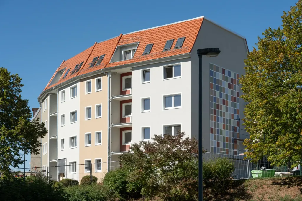 Sanierter Wohnblock mit Balkonen, Dachgauben und Fassadenmosaik der KOWO Obereichsfeld auf den Liethen in Heilbad Heiligenstadt