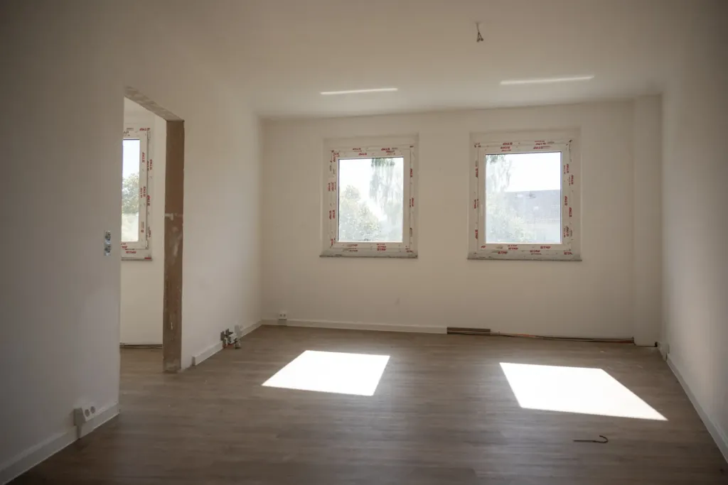 Leerer, frisch sanierter Wohnraum mit neuen Fenstern und Vinylboden in den neuen Familienwohnungen auf den Liethen