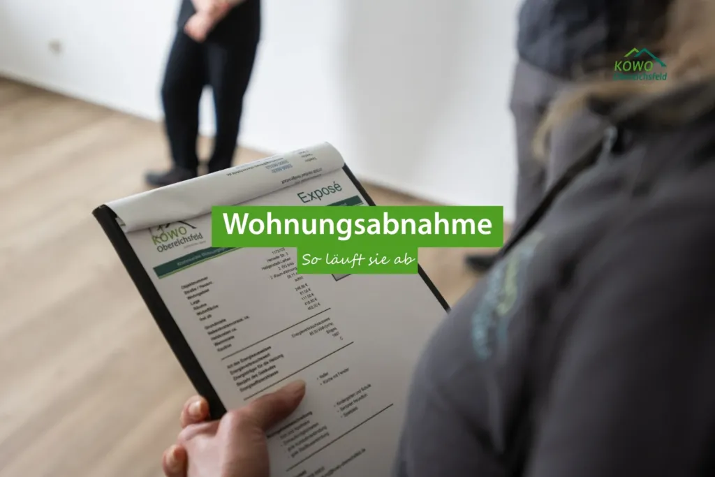 KOWO Obereichsfeld Mitarbeiterin bespricht Exposé bei der Wohnungsabnahme mit Mieter in leerer Wohnung