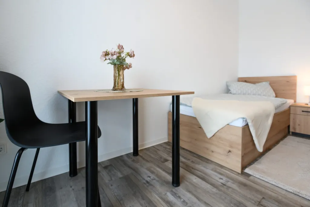 Möbliertes Zimmer im neuen Apartmenthaus Mescheder Straße 13 in Heilbad Heiligenstadt mit Bett, Schreibtisch und Stuhl