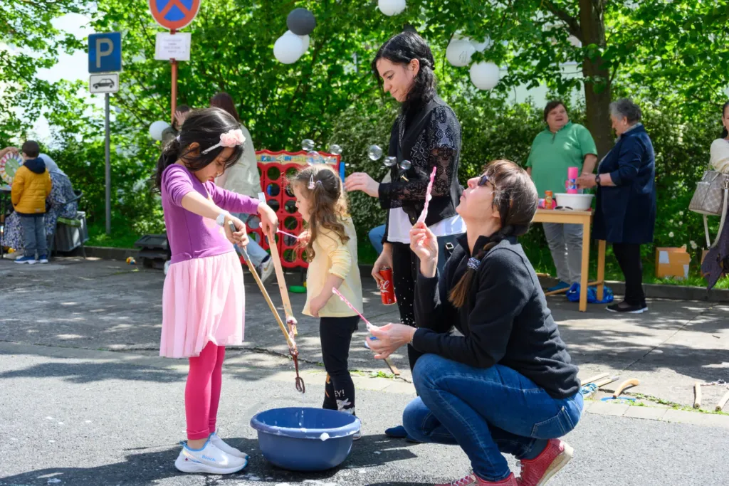 Kinder und Erwachsene spielen mit Seifenblasen beim Quartiersfest im Quartier 44 der KOWO Obereichsfeld
