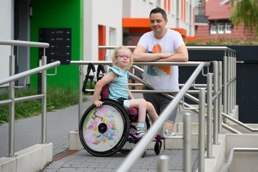 Mädchen im Rollstuhl mit Vater an barrierefreier Rampe in KOWO-Wohnanlage im Obereichsfeld