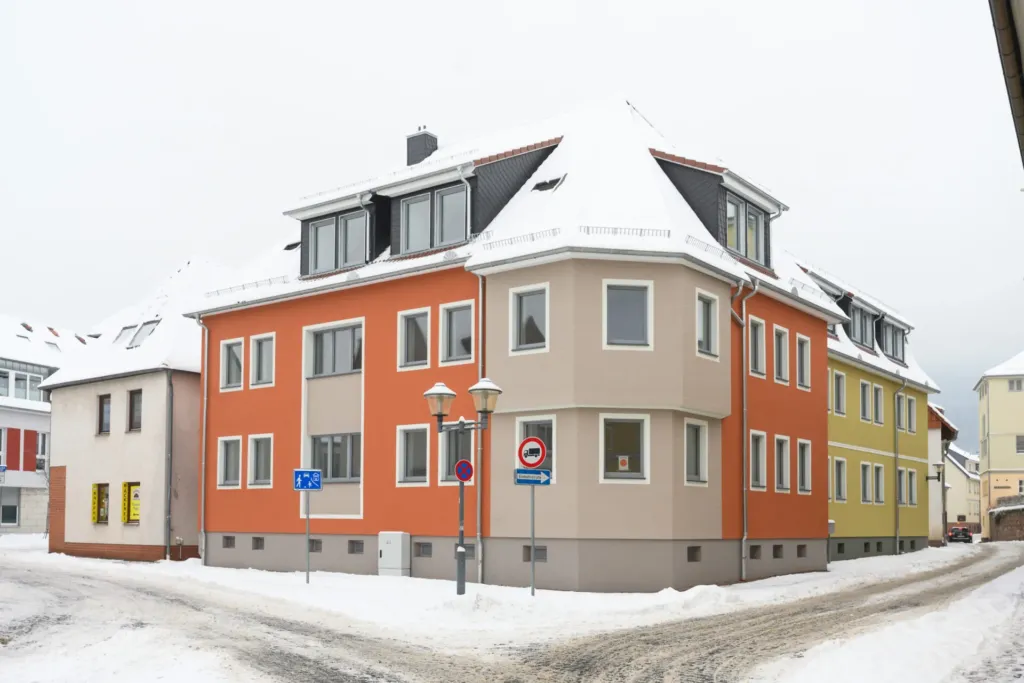 Saniertes Wohngebäude in der Ratsgasse 28, verputzte Fassade, winterliche Straßenansicht mit Verkehrsschildern.